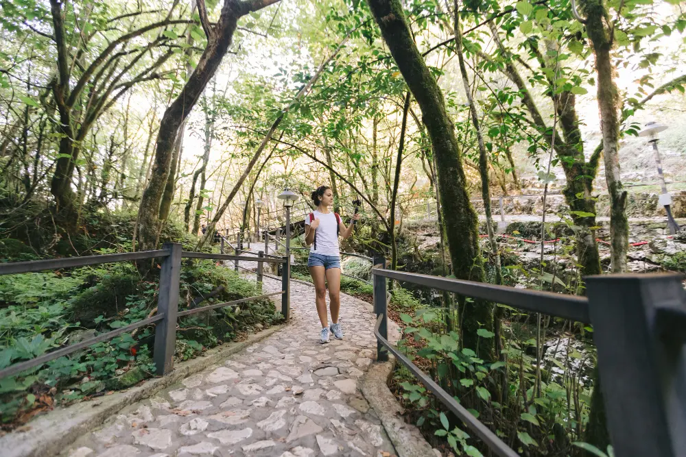 Mujer caminando en un parque rodeada de naturaleza, representando una técnica efectiva para aliviar los síntomas de la ansiedad generalizada.